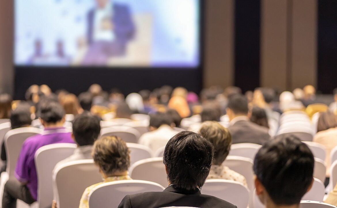 Rear view of Audience listening Speakers on the stage in the con